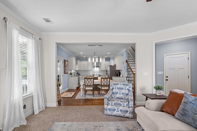 carpeted living area with crown molding, stairway, and baseboards