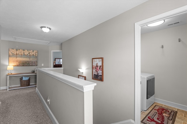 hall with attic access, an upstairs landing, washer / dryer, and baseboards