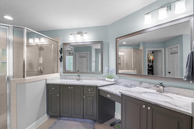 bathroom featuring a shower stall, vanity, and a walk in closet