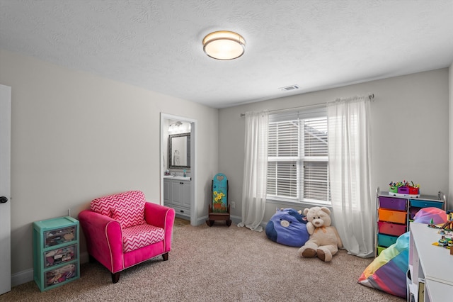 playroom featuring carpet floors, a textured ceiling, and baseboards