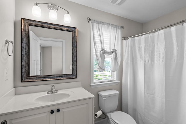 bathroom with toilet, vanity, and a shower with curtain