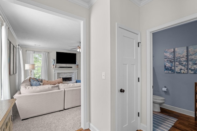 hall with wood finished floors, crown molding, and baseboards