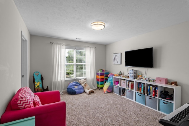 rec room featuring carpet flooring, a textured ceiling, and baseboards