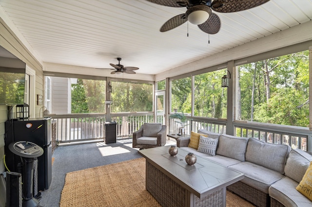 sunroom featuring ceiling fan and an outdoor living space