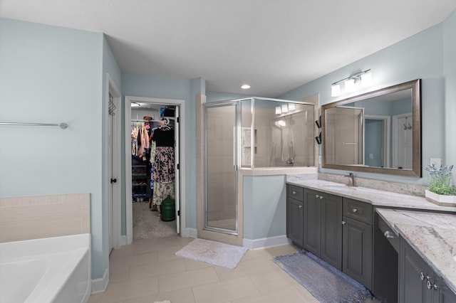 full bath featuring a shower stall, vanity, a spacious closet, and a garden tub