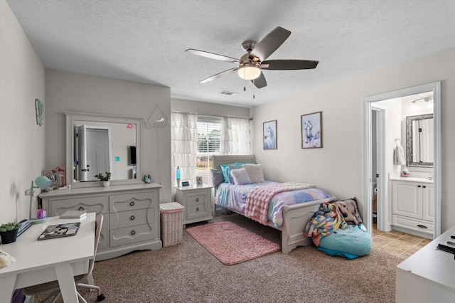 bedroom featuring a textured ceiling, ceiling fan, and ensuite bathroom