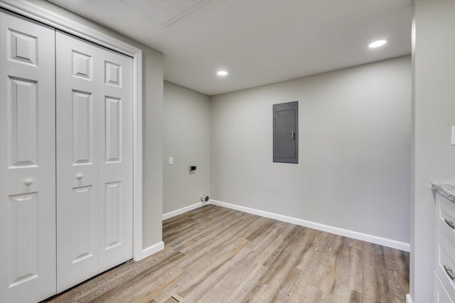 laundry area featuring electric panel, light hardwood / wood-style flooring, and electric dryer hookup