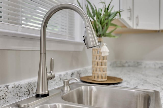 room details featuring sink and white cabinets