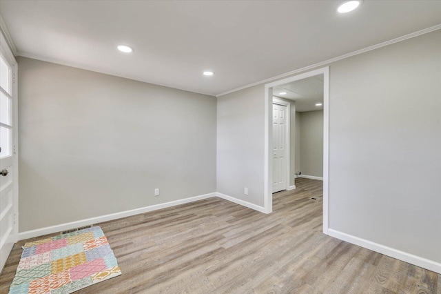 spare room with crown molding and light hardwood / wood-style floors