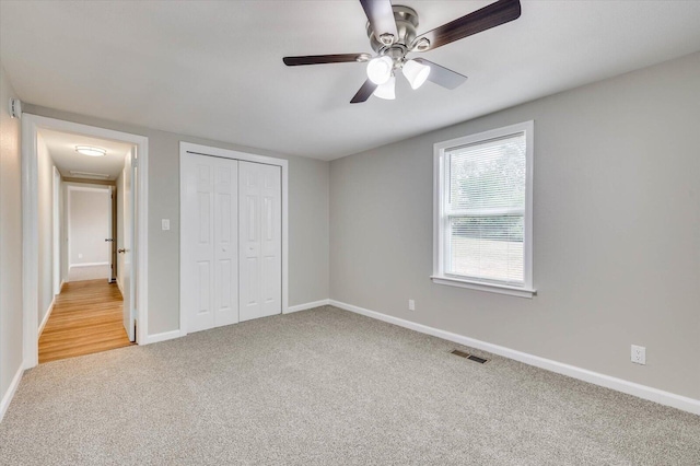 unfurnished bedroom with carpet floors, a closet, and ceiling fan