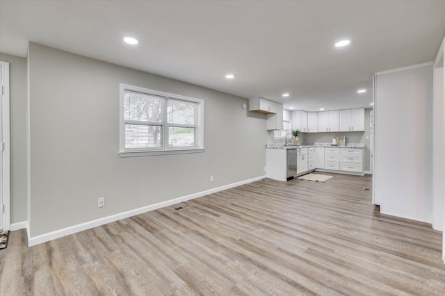 unfurnished living room with sink and light hardwood / wood-style floors