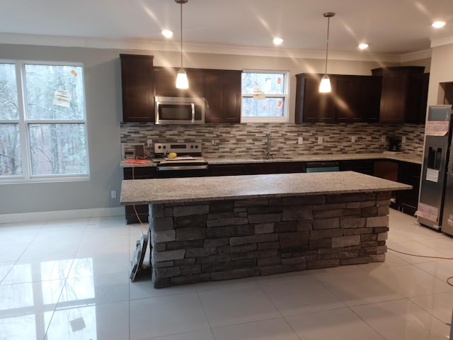 kitchen featuring sink, hanging light fixtures, crown molding, decorative backsplash, and appliances with stainless steel finishes