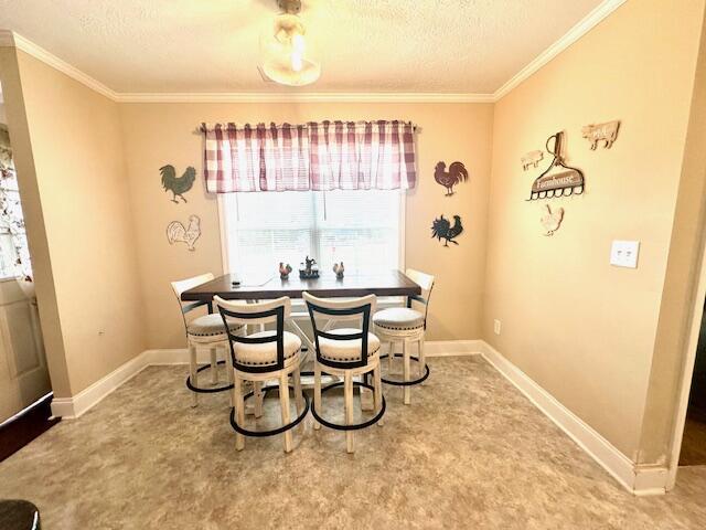 dining area featuring a textured ceiling and crown molding