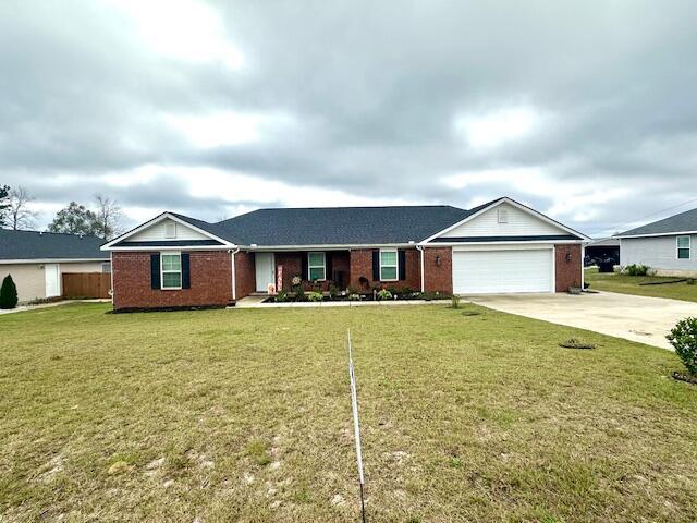 ranch-style house featuring a garage and a front lawn