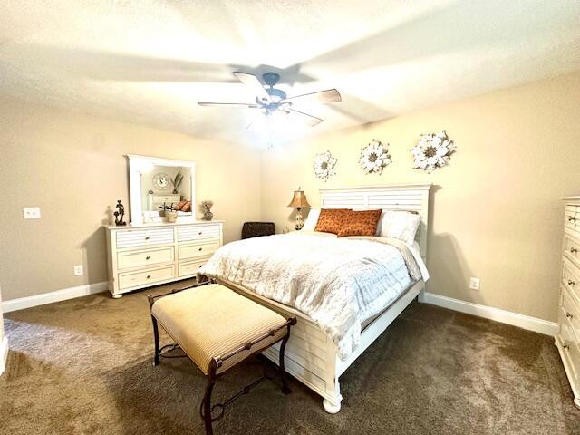 bedroom with ceiling fan and dark colored carpet