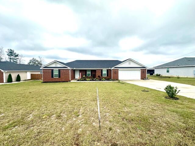 single story home featuring a garage and a front lawn