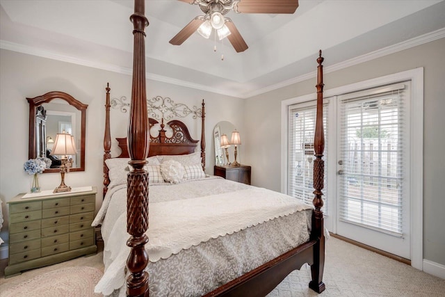 bedroom with a ceiling fan, ornamental molding, access to exterior, a tray ceiling, and carpet floors