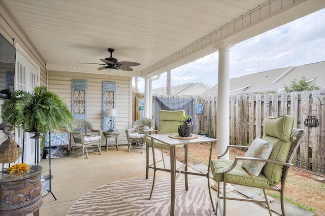 sunroom / solarium featuring ornate columns and a ceiling fan