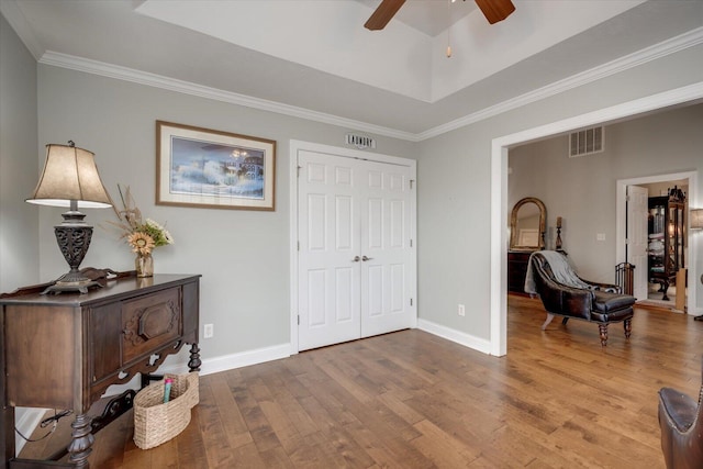 sitting room with wood finished floors, visible vents, and baseboards