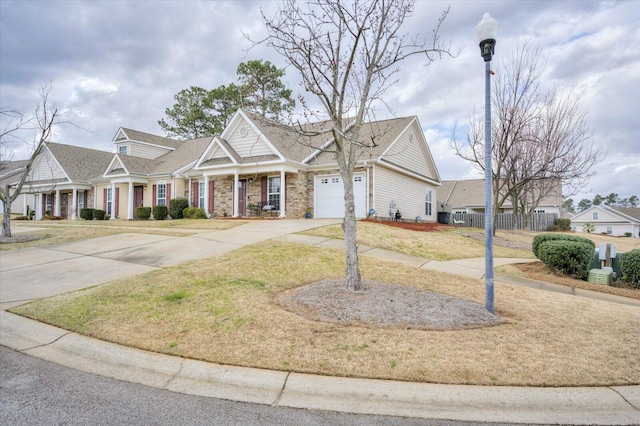 view of front facade with driveway, a garage, fence, and a front lawn