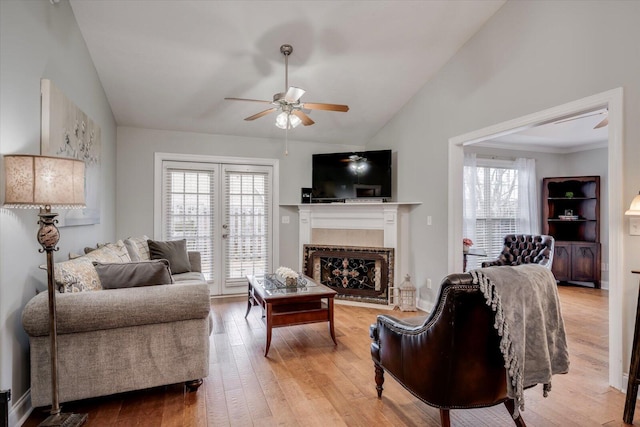 living area with light wood-type flooring, vaulted ceiling, and a wealth of natural light