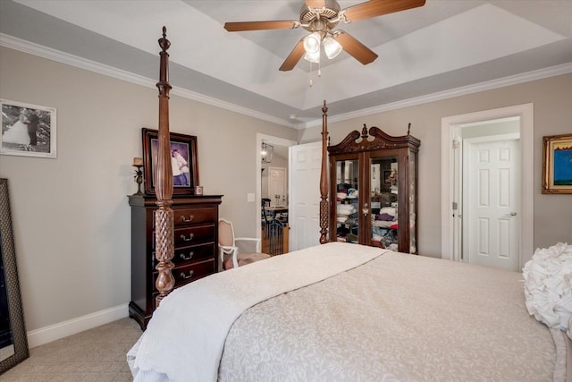 bedroom with ornamental molding, a raised ceiling, light colored carpet, and baseboards