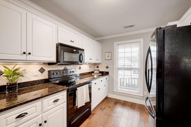 kitchen featuring crown molding, light wood finished floors, visible vents, white cabinetry, and black appliances