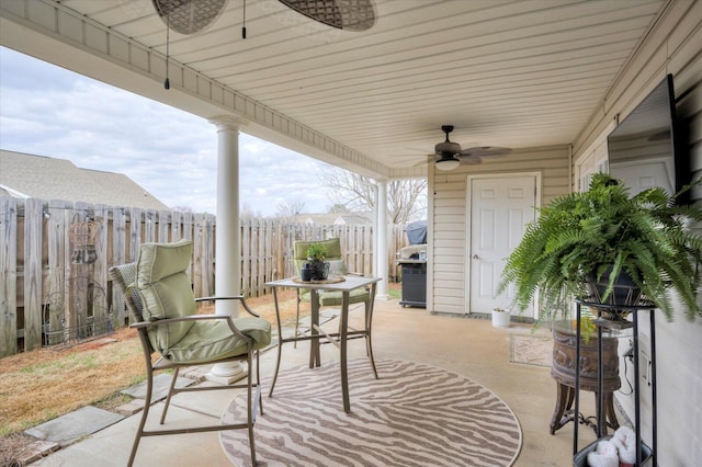 view of patio / terrace with ceiling fan and fence