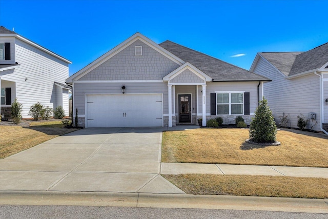 craftsman house featuring stone siding, a front lawn, an attached garage, and driveway