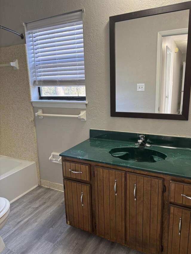 full bathroom with shower / bathing tub combination, hardwood / wood-style floors, vanity, and toilet