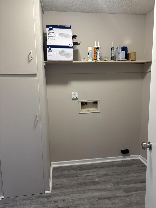 laundry room with hookup for a washing machine, dark wood-type flooring, and a textured ceiling