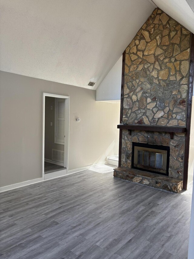 unfurnished living room with a fireplace, hardwood / wood-style flooring, and vaulted ceiling