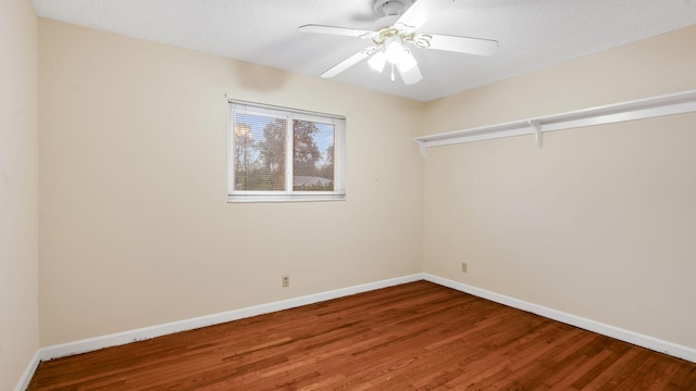 spare room featuring a textured ceiling, wood finished floors, a ceiling fan, and baseboards