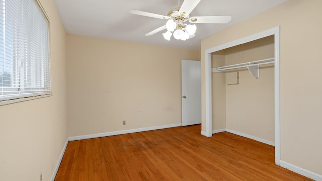 unfurnished bedroom with a closet, ceiling fan, baseboards, and wood finished floors