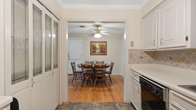 kitchen with dishwasher, dark wood-style floors, ornamental molding, light countertops, and white cabinetry