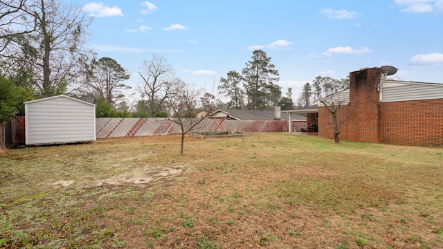 view of yard with a storage shed, fence, and an outdoor structure