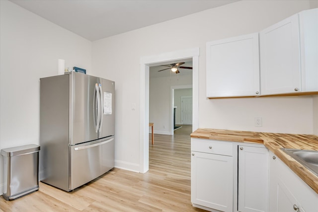 1107 Adrian St, Augusta, GA 30904 - kitchen with freestanding refrigerator, wood counters, light wood-style flooring, and white cabinetry