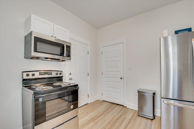 1107 Adrian St, Augusta, GA 30904 - kitchen featuring appliances with stainless steel finishes, light wood finished floors, white cabinets, and baseboards
