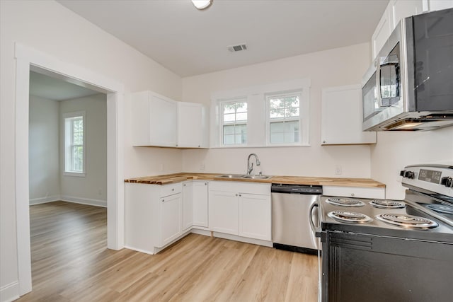 1107 Adrian St, Augusta, GA 30904 - kitchen with stainless steel appliances, butcher block countertops, a sink, and light wood-style flooring