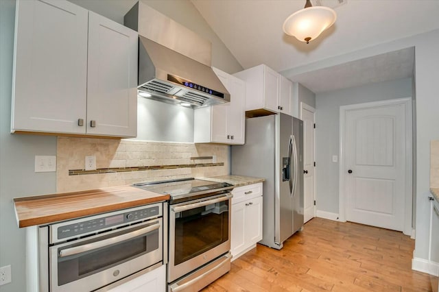 702 Southwick Ave, Grovetown, GA 30813 - kitchen with wall chimney exhaust hood, appliances with stainless steel finishes, light wood-style floors, white cabinetry, and decorative backsplash