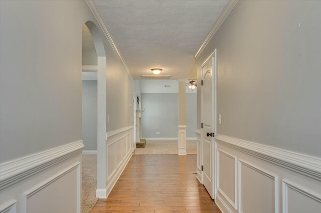 702 Southwick Ave, Grovetown, GA 30813 - corridor featuring light wood-style flooring, crown molding, a wainscoted wall, a decorative wall, and arched walkways