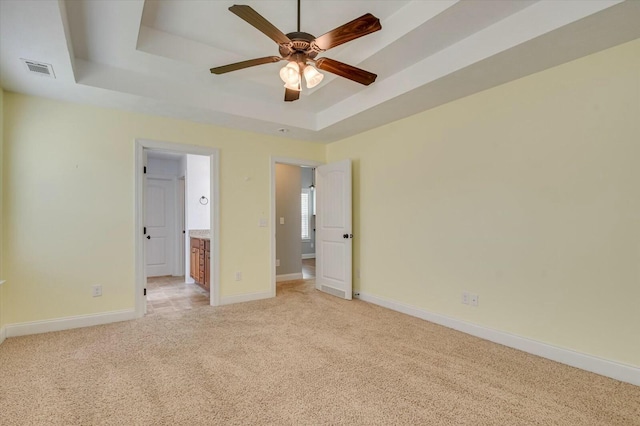 702 Southwick Ave, Grovetown, GA 30813 - unfurnished bedroom featuring visible vents, baseboards, a tray ceiling, ensuite bath, and light colored carpet