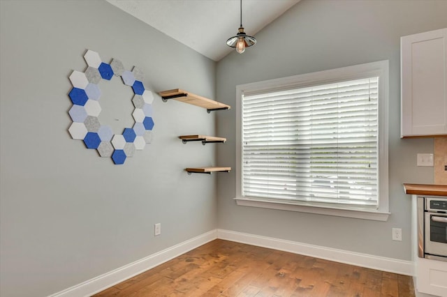 702 Southwick Ave, Grovetown, GA 30813 - unfurnished dining area with wood finished floors, baseboards, and vaulted ceiling