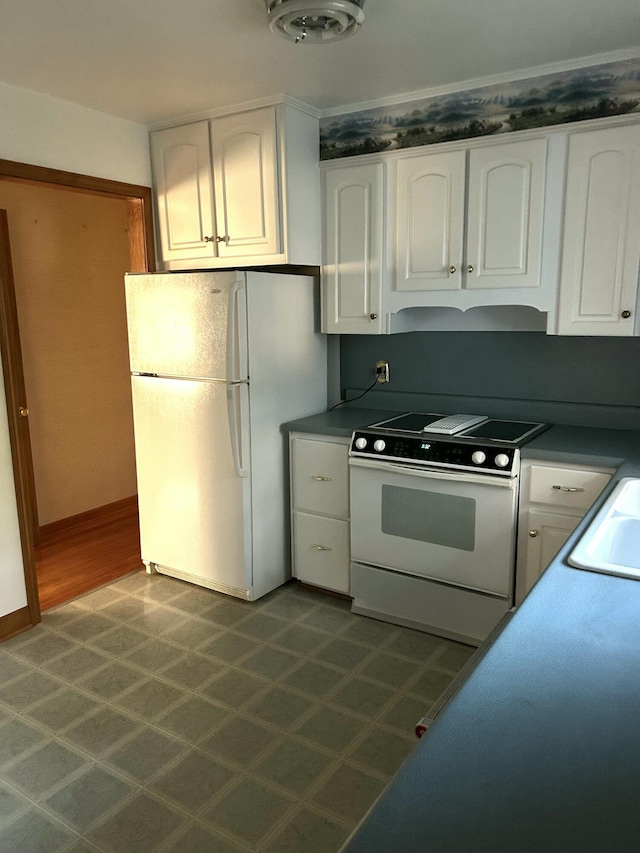 kitchen featuring sink, white appliances, and white cabinets