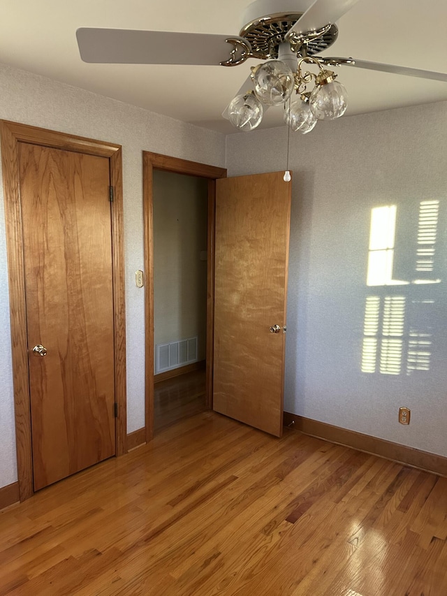 unfurnished bedroom with light hardwood / wood-style flooring, a closet, and ceiling fan