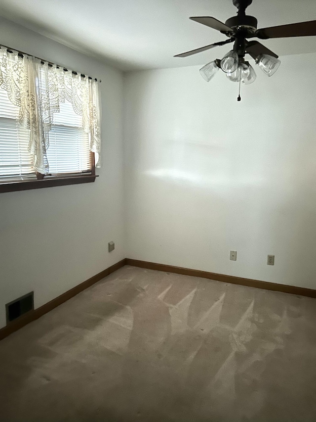 carpeted spare room with ceiling fan