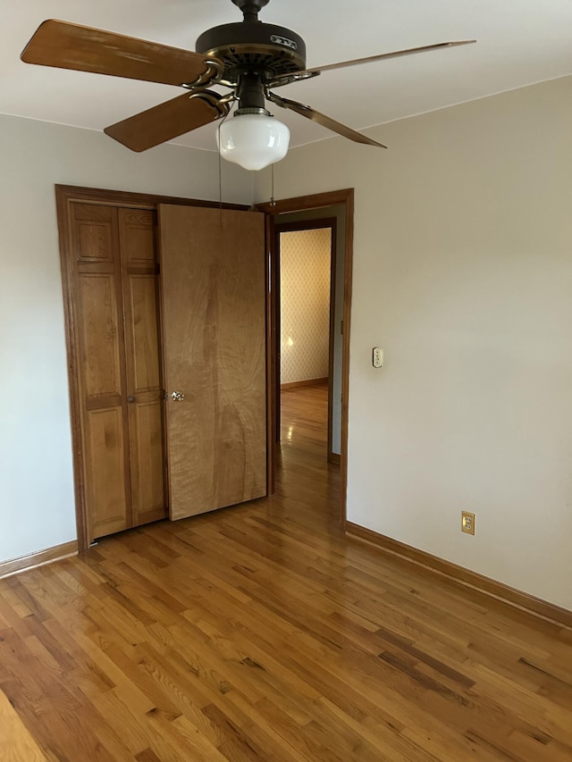 unfurnished bedroom featuring ceiling fan, light wood-type flooring, and a closet