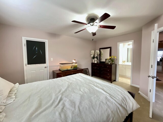 bedroom featuring light carpet, connected bathroom, and ceiling fan