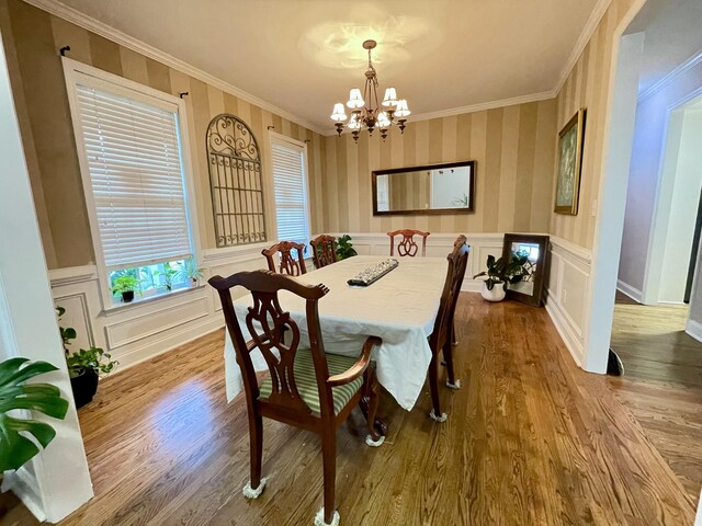 dining room featuring wood-type flooring, crown molding, and a chandelier