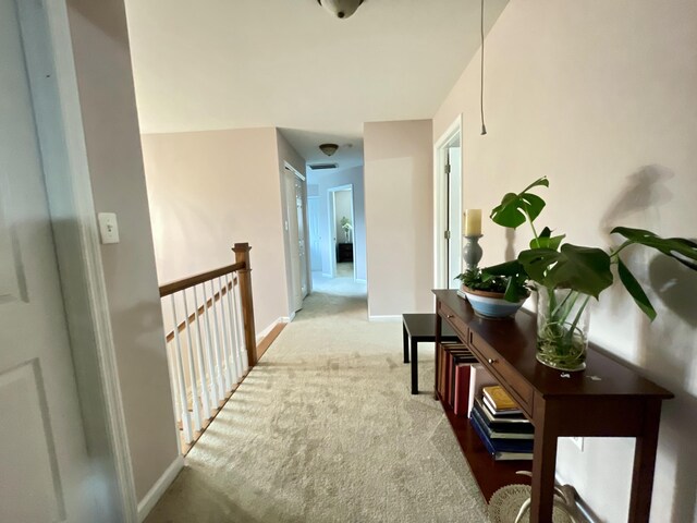 hallway featuring light colored carpet